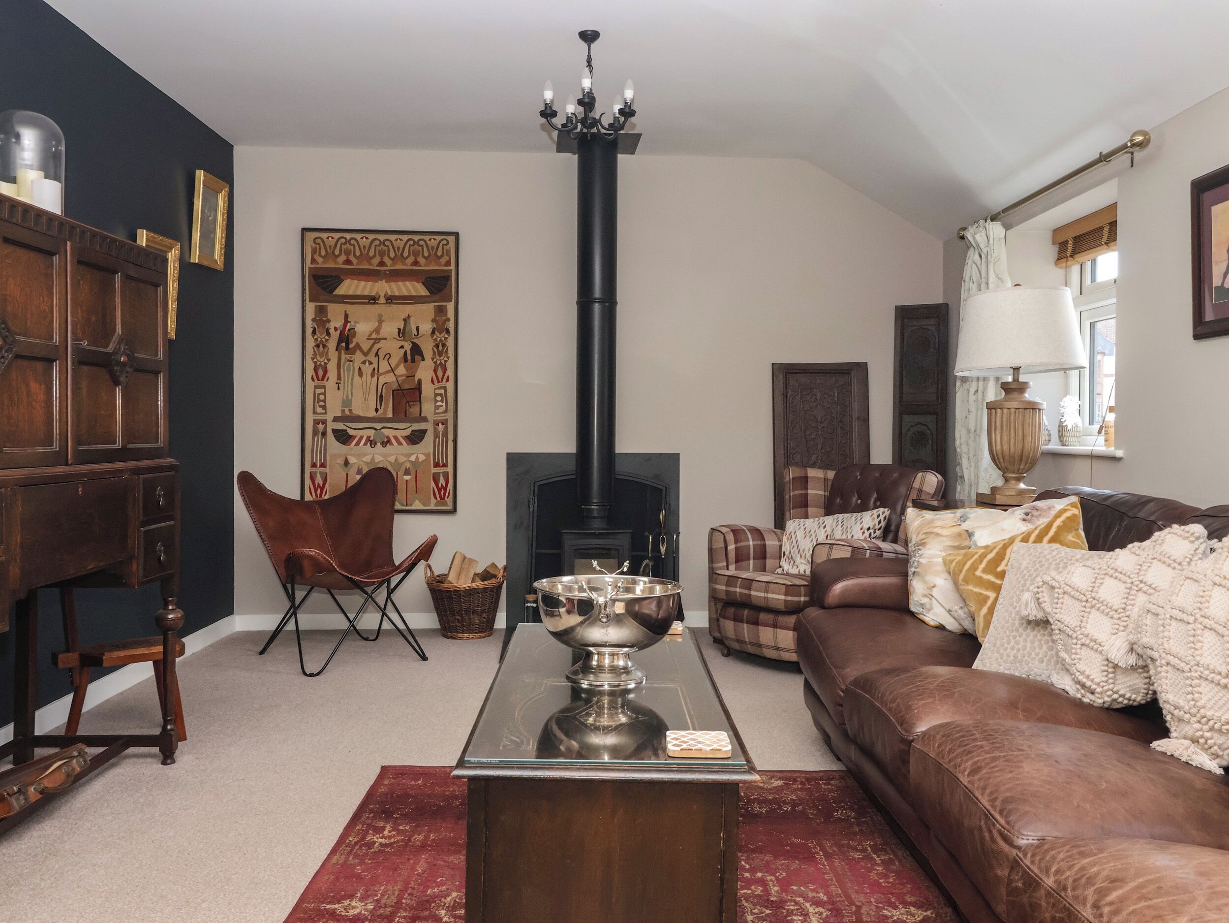 A living room with a fireplace, a sofa, a chair, and a table.