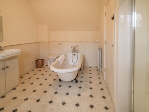 A bathroom with a bathtub, toilet, and sink. - Robertson's Cottage (Caledon)