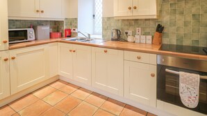 A kitchen with white cabinets, a microwave, a coffee maker, and a dishwasher.