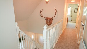 Una escalera con una calavera de ciervo montada en la pared superior.