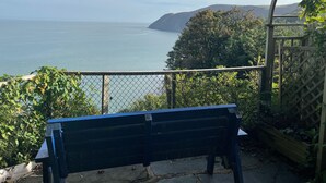 A bench overlooking a coastal view with a clear sky. - Blue Bay (Lynton)