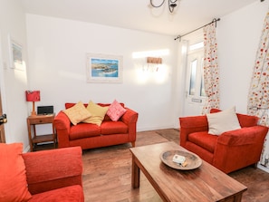 A living room with a red sofa set, a wooden coffee table, and a painting on the wall.