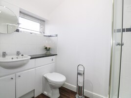 Un baño moderno con lavamanos, inodoro y ducha blancos.