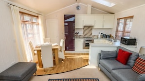 A compact living space with a dining area, kitchenette, and a sofa. - Jules @ 79 (Narberth)
