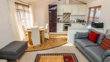 Un espace de vie compact comprenant un coin repas, une kitchenette et un canapé.