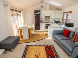Un espacio habitable compacto con comedor, kitchenette y sofá.