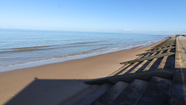 A beach with a concrete walkway and a clear view of the ocean. - Ash Farm Cottage (Holywell)