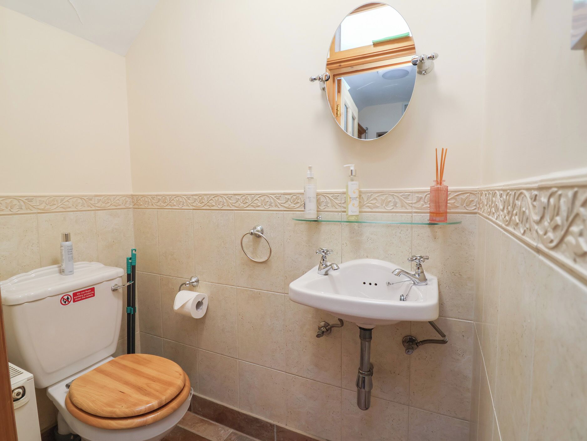A bathroom with a toilet, sink, and mirror.