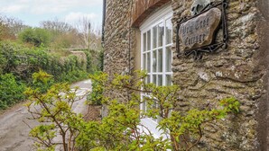 Un bâtiment en pierre sur lequel on peut lire l’inscription : « The Old Cottage ».