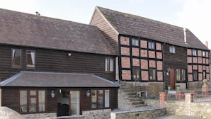 A traditional half-timbered building with a stone foundation and a wooden extension. - Alders View Coach House (Craven Arms)