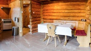 A log cabin interior with a dining table, chairs, and a bench. - Cozy Log Chalet with Terrace, Near Alsace and Ski Resorts (Le Saulcy)