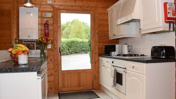 A compact kitchen with white cabinets, a microwave, a toaster, and a gas stove.