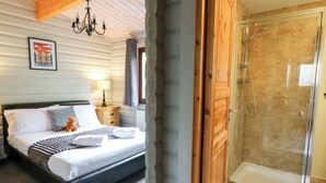 A bedroom with a bed, bedside table, lamp, and a framed picture on the wall. - Mountain View (Rhayader)