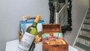 A bottle of wine, a box of Nescafé Original packets, and a decorative mirror on a table.