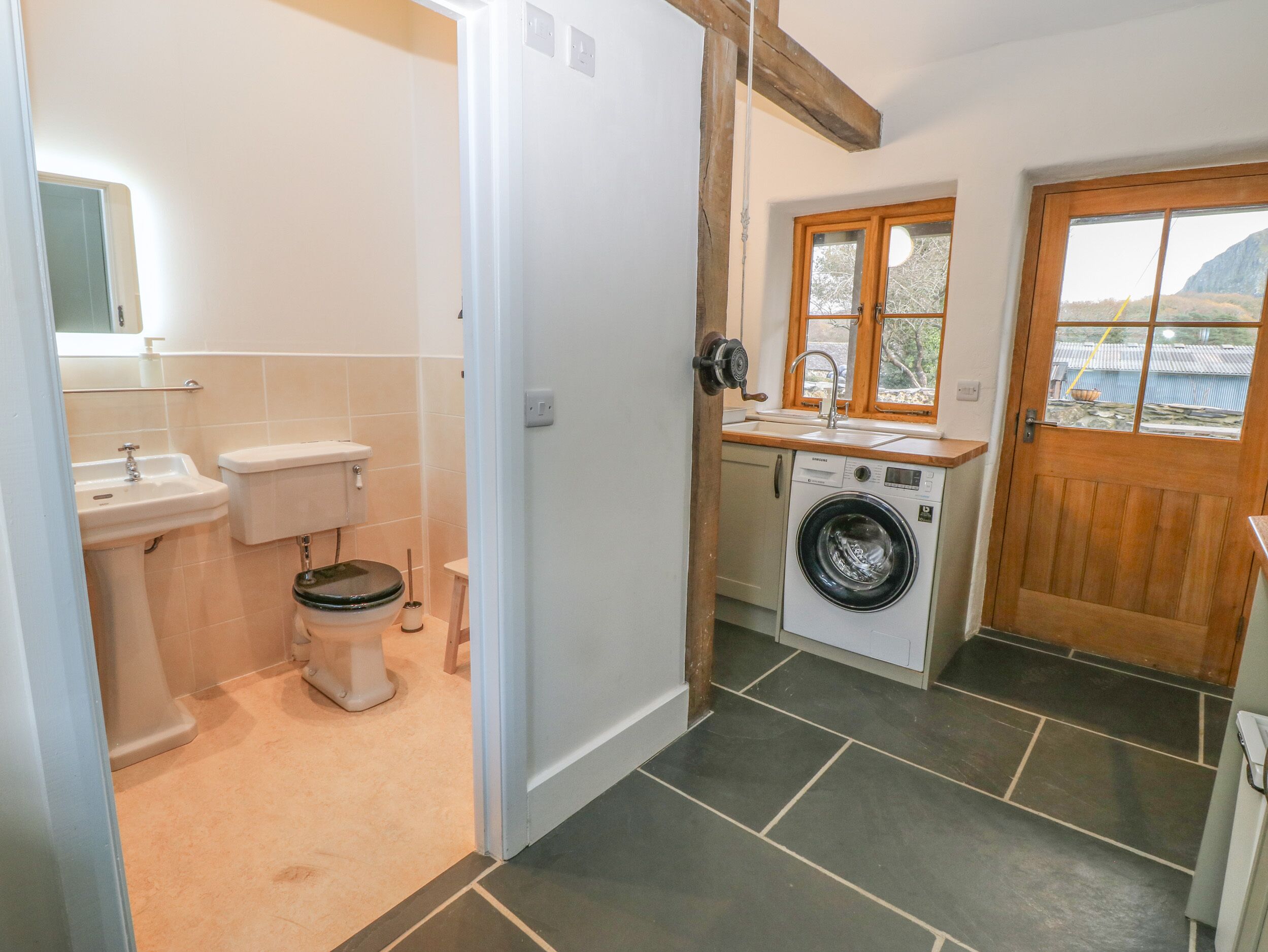 A compact bathroom with a toilet, sink, and washing machine.