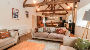 A cozy living room with a sofa set, wooden coffee table, and a fireplace. - The Old Workshop (Belford)