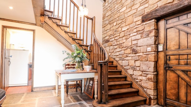 A staircase with wooden railings leading to a stone wall. - The Boot Room (Preston)
