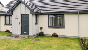 A modern building with a grey roof, a small porch, and a door marked with the number 10. - Skoglendi (Boat of Garten)