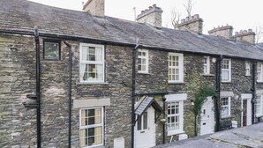 A row of stone buildings with multiple windows and a small door. - Dalesway Cottage (Windermere)
