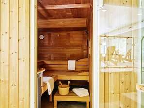 A wooden sauna room with benches, a table, and a bucket. - Gitcombe Retreat (Totnes)