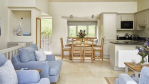 A spacious living room with a dining area, a kitchen, and a view of the outdoors. - Burrator Cottage (Totnes)
