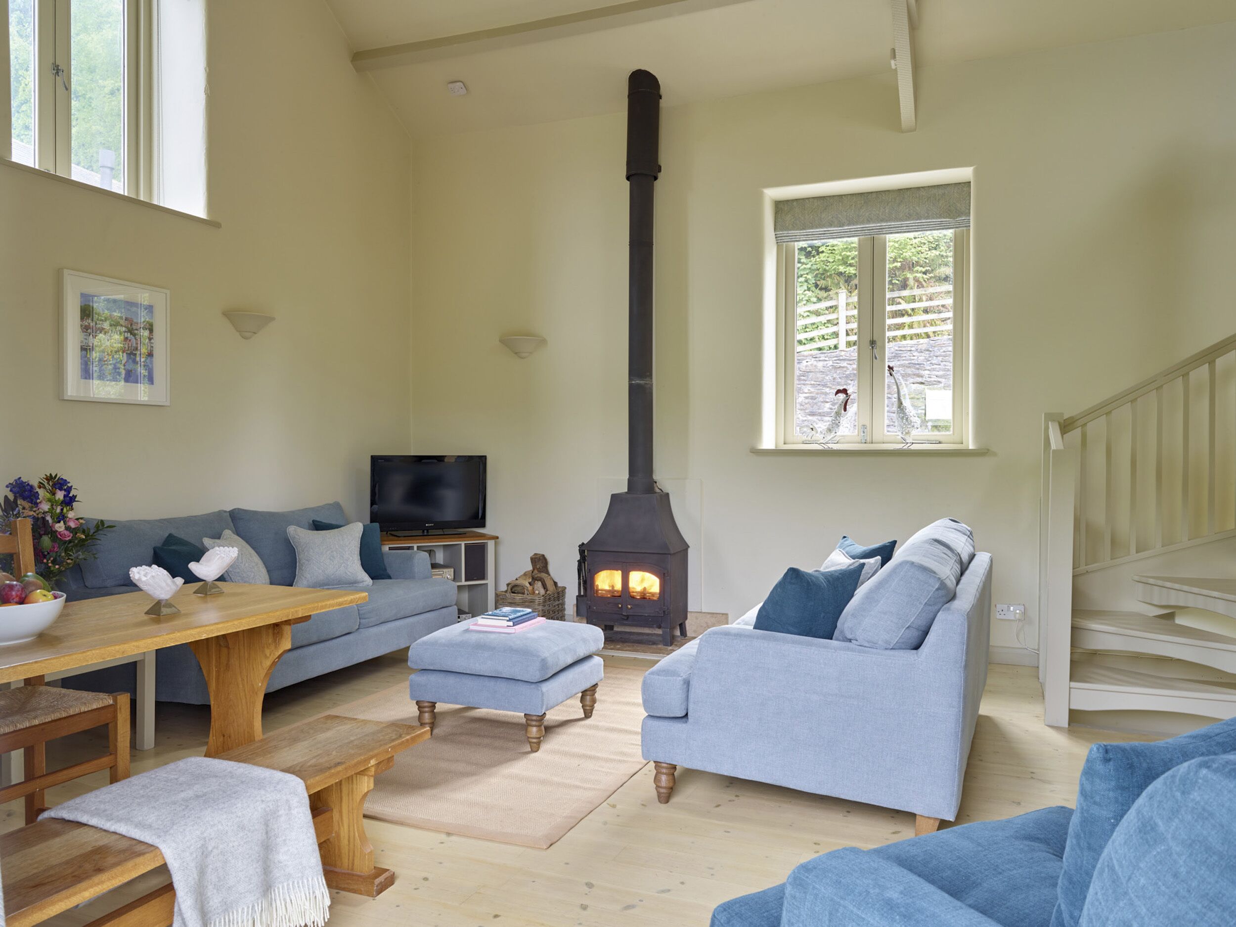A cozy living room with a fireplace, a sofa, a TV, and a dining area.