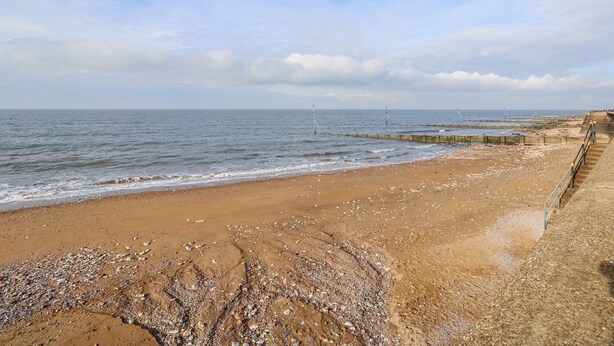 A beach with a sandy shore and a rocky area in the foreground. - Honeybees Haven (Hunstanton)