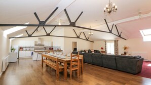 Un loft spacieux comprenant un coin repas, une cuisine et un espace de vie.