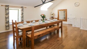 Comedor con mesa de madera para cuatro, un banco e iluminación de candelabro.