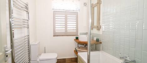 A compact bathroom with a toilet, sink, and bathtub.