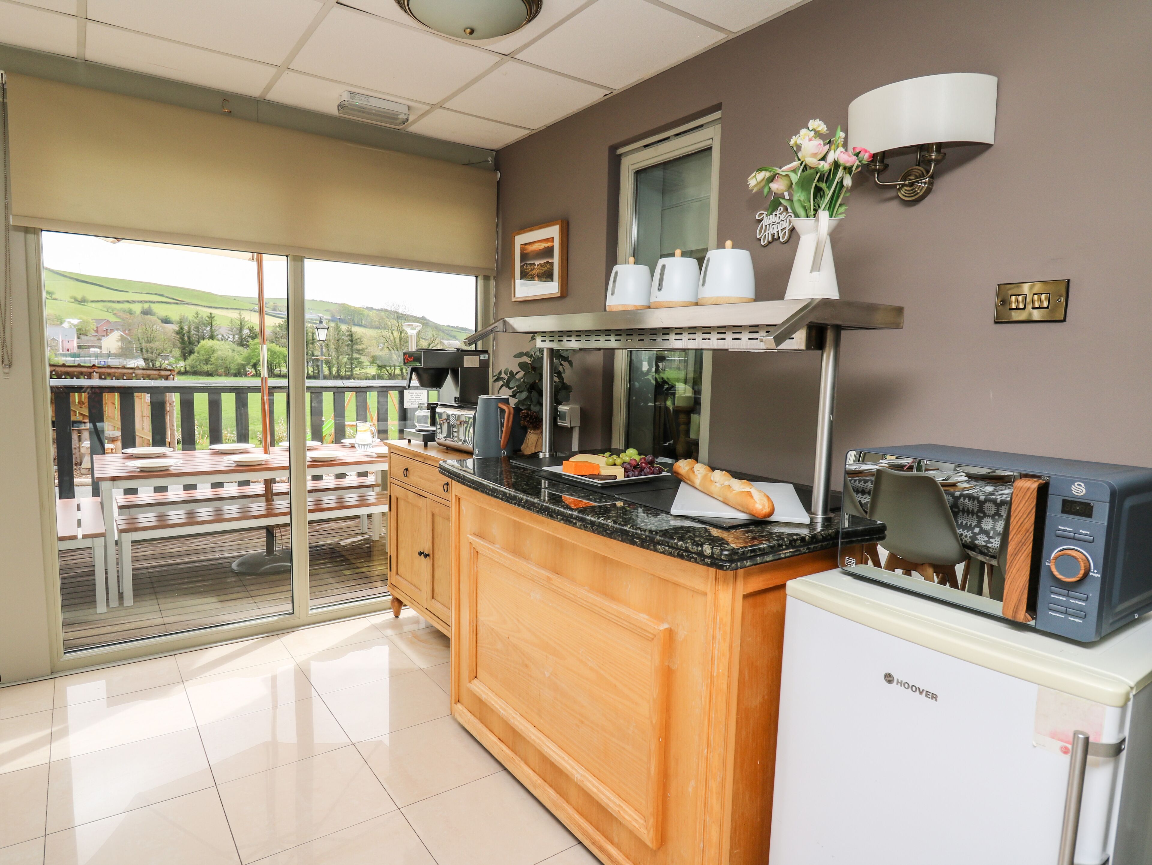 A kitchen with a built-in oven, a refrigerator, and a coffee maker.