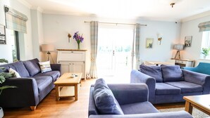 A living room with two sofas, a coffee table, and a small table with a lamp. - Llety Ceiro (Bow Street)