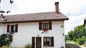 A two-story house with a tiled roof, a front door, and windows with shutters. - Family-Friendly Countryside Cottage with Modern Amenities, Near Thermal Baths and Nature Spots (Le Val-d'Ajol)