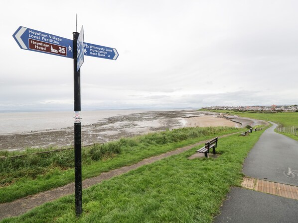 A directional signpost with multiple arrows pointing towards Heysham Head, local facilities, and Whinnysty Lane. - Cosy Bee (Morecambe)