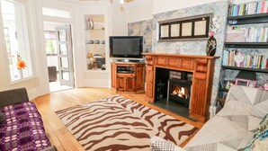 Ein Wohnzimmer mit Kamin, Fernseher und Bücherregal.