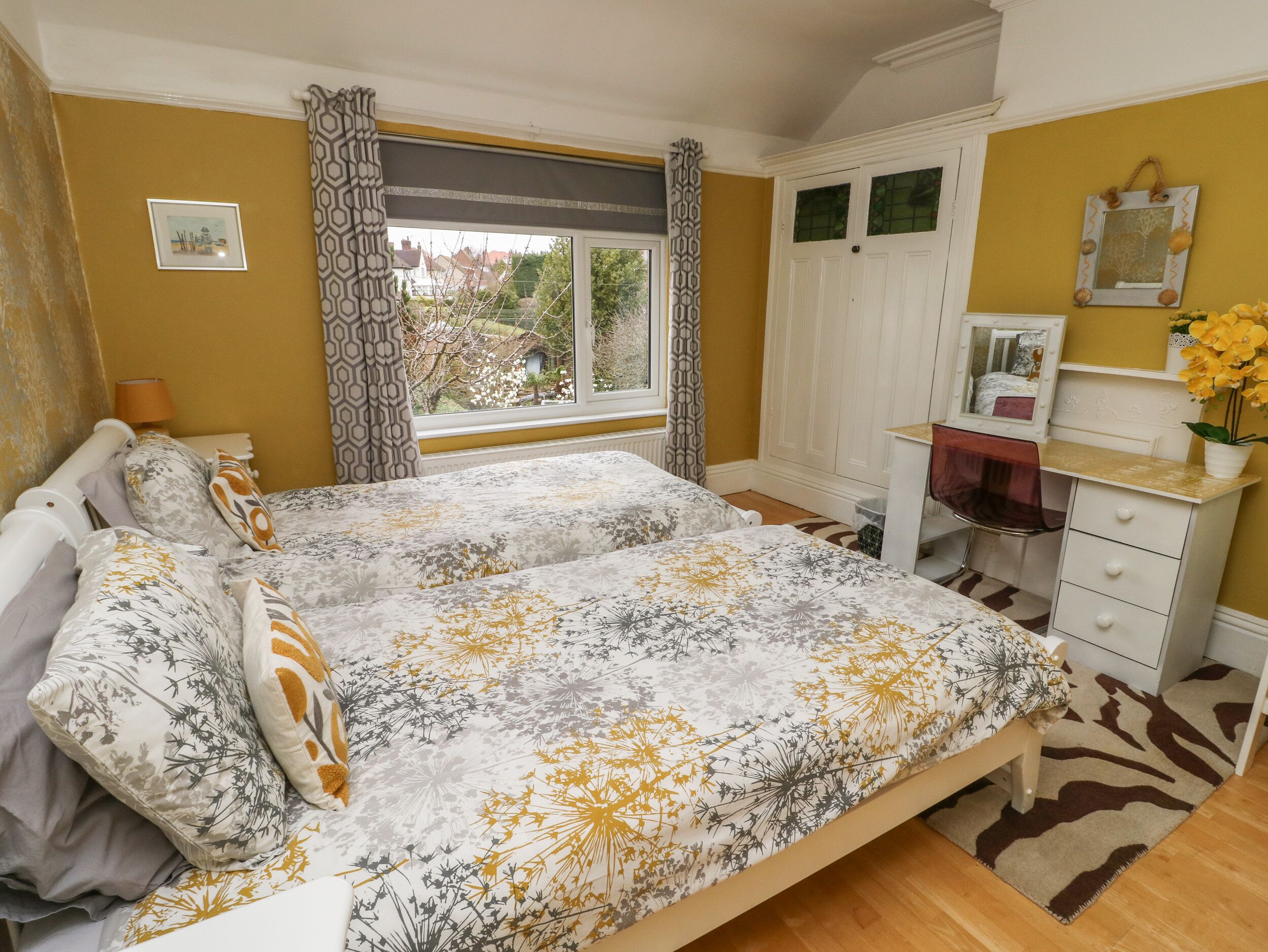 A bedroom with a bed, a desk, and a window.