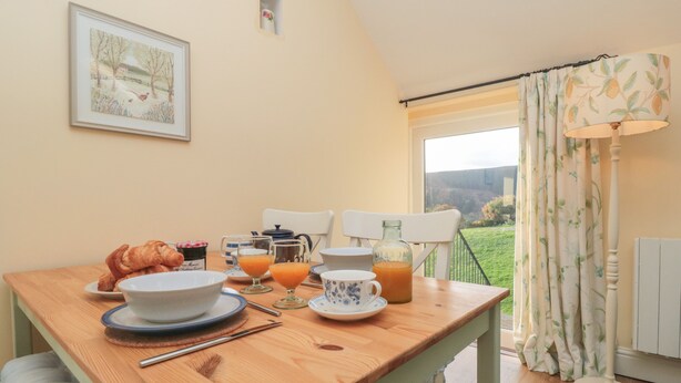 Una mesa de desayuno con croissants, jugo de naranja y café.