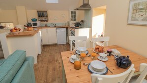 Una cocina acogedora con comedor, suelo de madera y vistas al campo.
