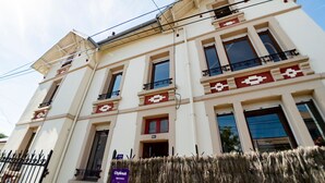 Edifício de vários andares com fachada simétrica, apresentando uma série de janelas e sacadas.
