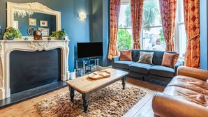 A living room with a fireplace, a television, a sofa, and a coffee table.