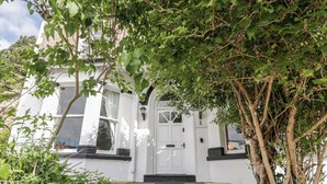 A white building with a white door and black steps leading up to it.