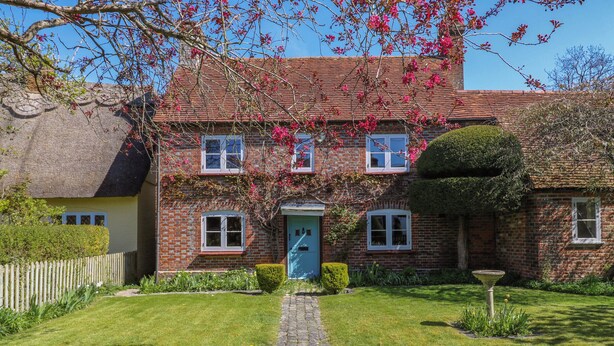 A traditional brick house with a thatched roof, a blue door, and a paved pathway leading to the entrance. - Bakehouse Farm (Princes Risborough)