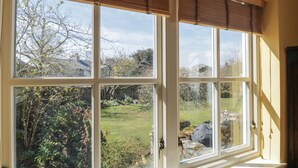 Una habitación con un amplio ventanal con vistas a un jardín.