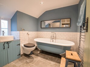 A bathroom with a freestanding bathtub, a toilet, and a sink. - Bwthyn Dyfi (Machynlleth)