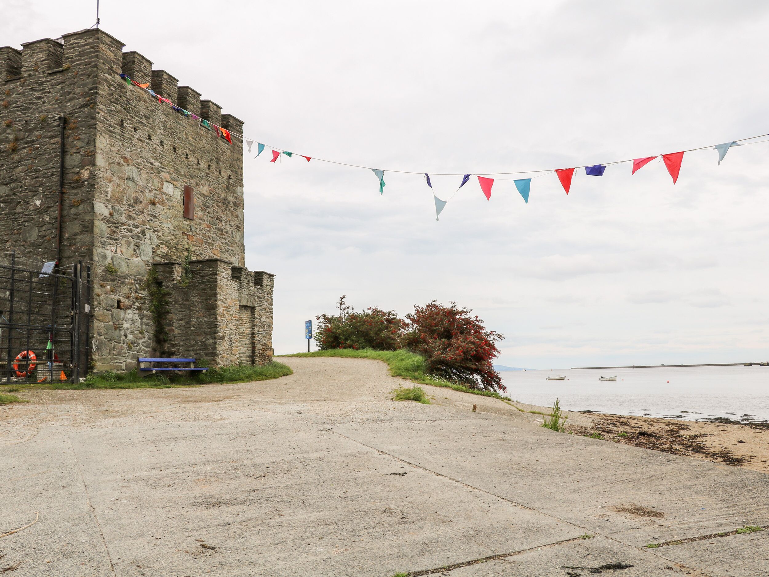 A stone building with a pathway leading to a beach.