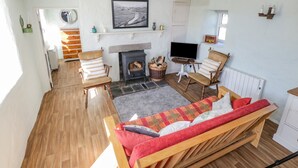 Un salon chaleureux avec une cheminée, un téléviseur et des fauteuils confortables.