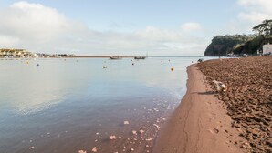A beach with calm water, boats, and a sandy shore. - Teign Cottage (Teignmouth)