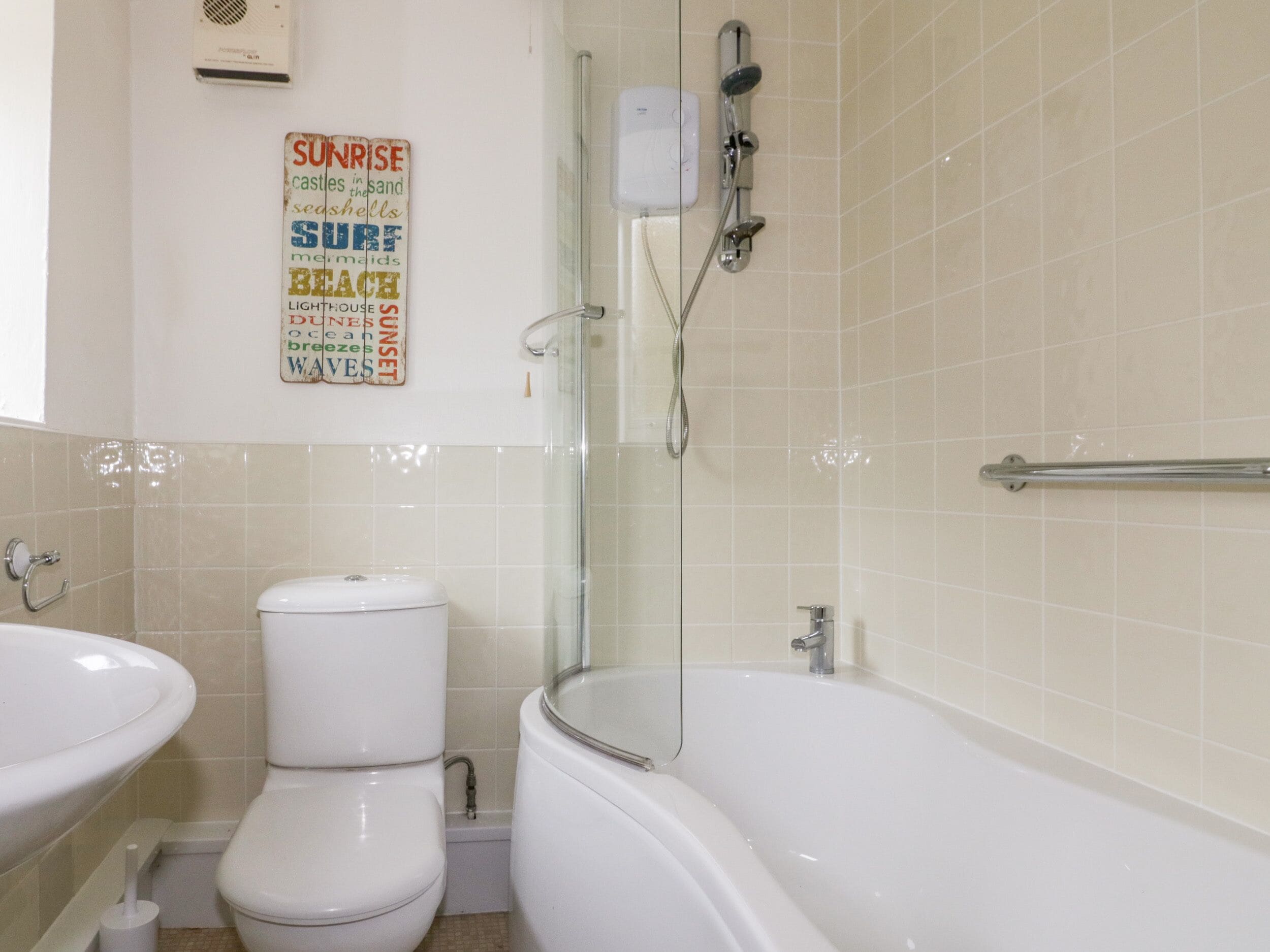 Une salle de bain avec des toilettes, un lavabo et une baignoire.