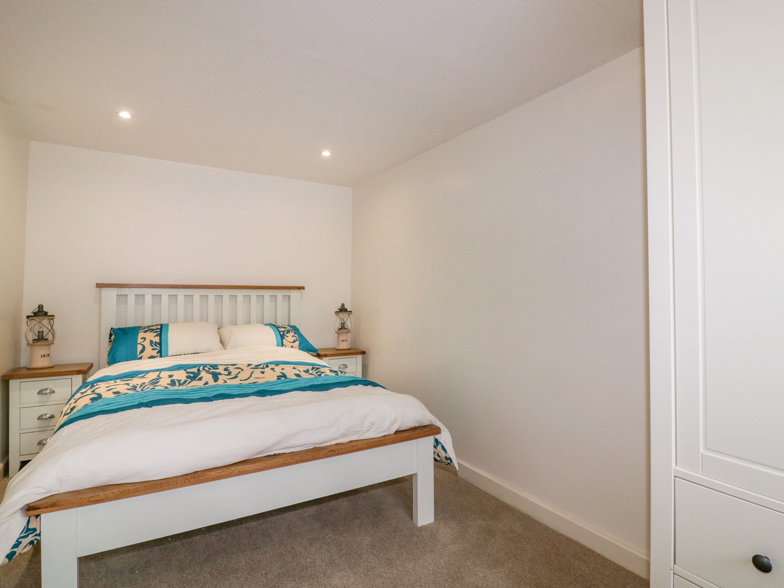 A bedroom with a bed, nightstands, and a wardrobe.
