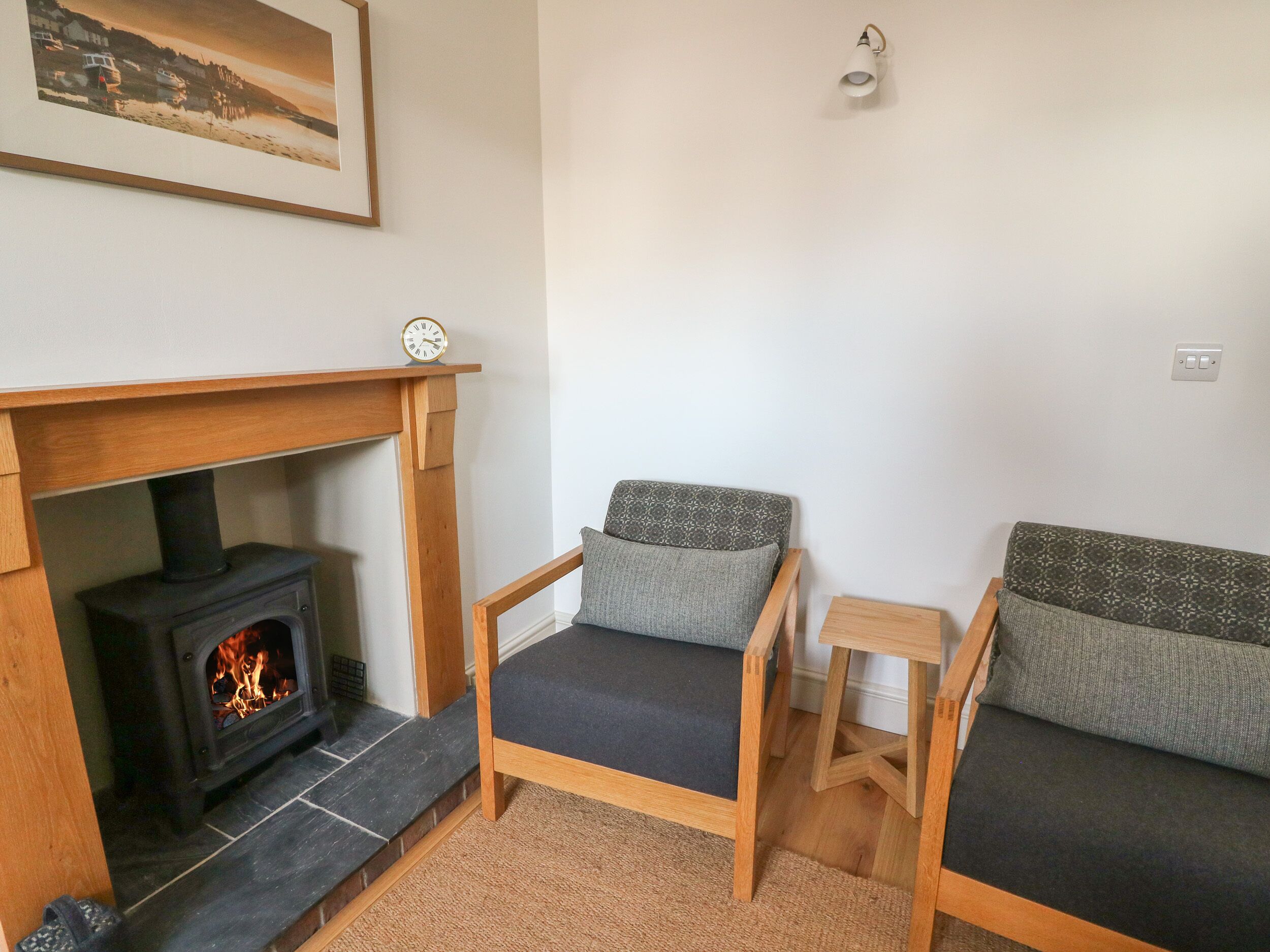 A cozy living room with a fireplace, a sofa, and a chair.